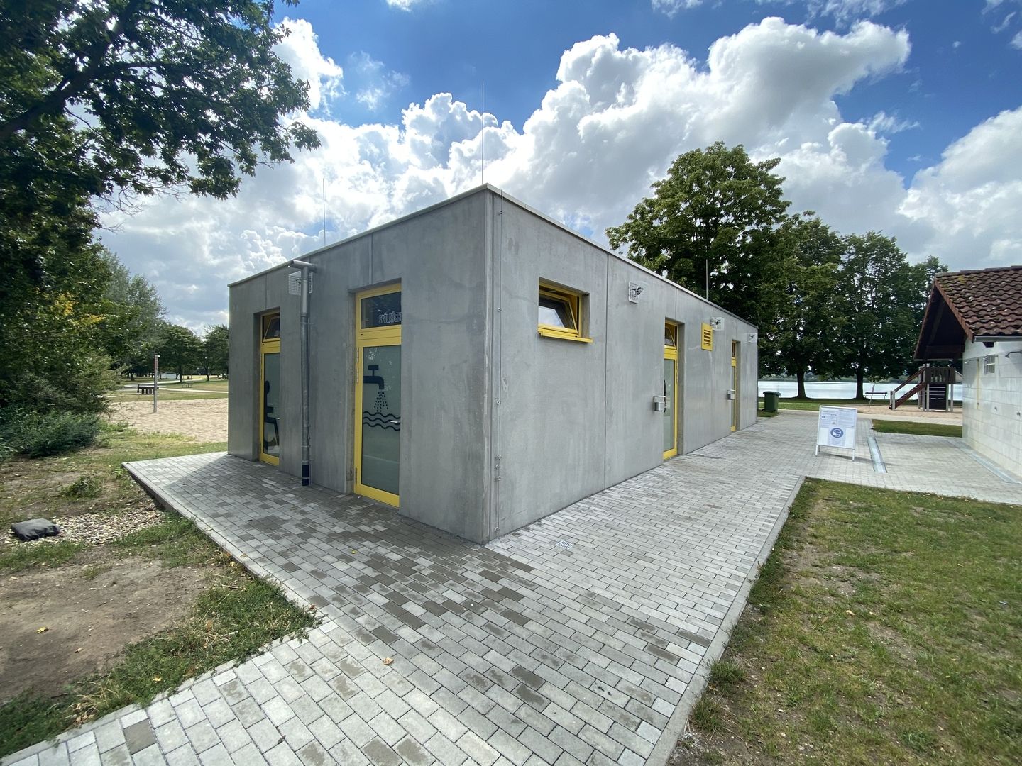 Freizeitzentrum Hardtsee Ubstadt-Weiher: Sanitärgebäude aus Sichtbeton mit gelben Türen am Baggersee